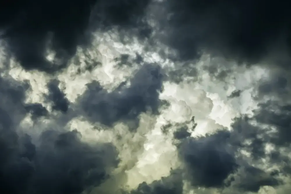 Storm clouds in summer Ragged wind-driven dark clouds move in quickly to obscure large white billows before sunset, for meteorological themes of instability and rapid change