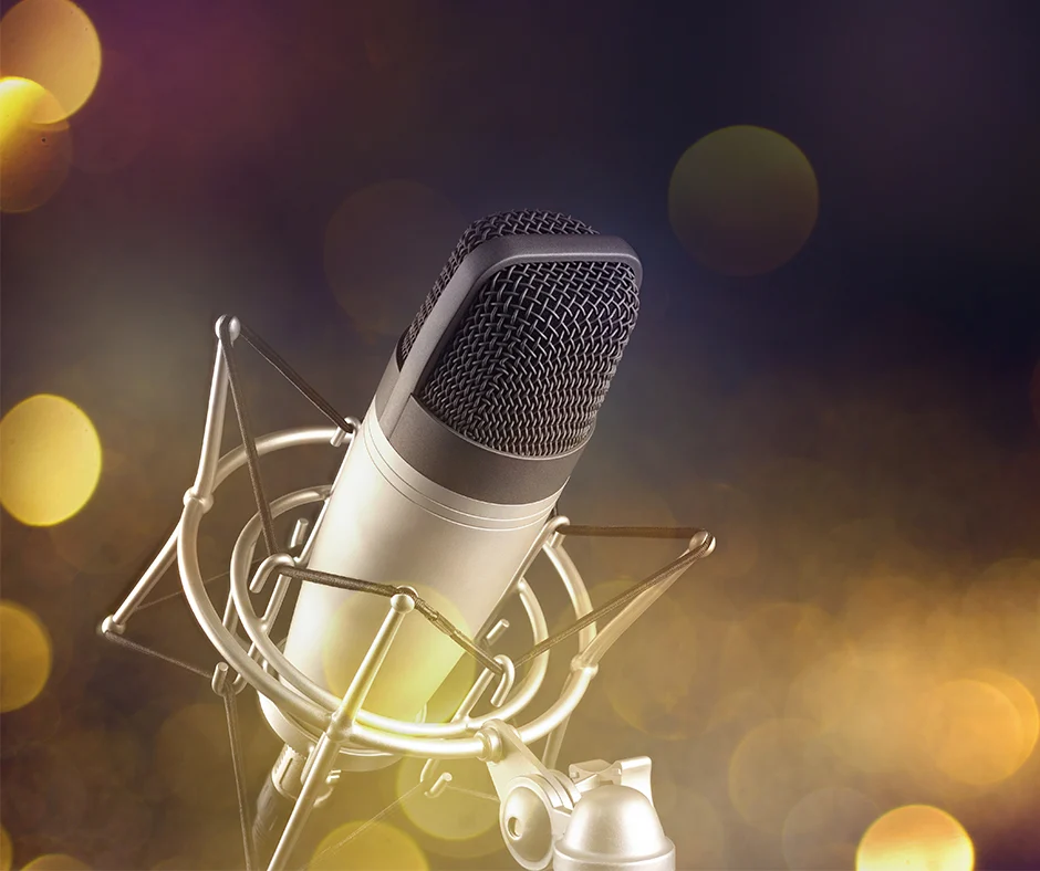 gray-studio-condenser-microphone-shock-mount-blur-festive-holiday-lights-surface-940x768